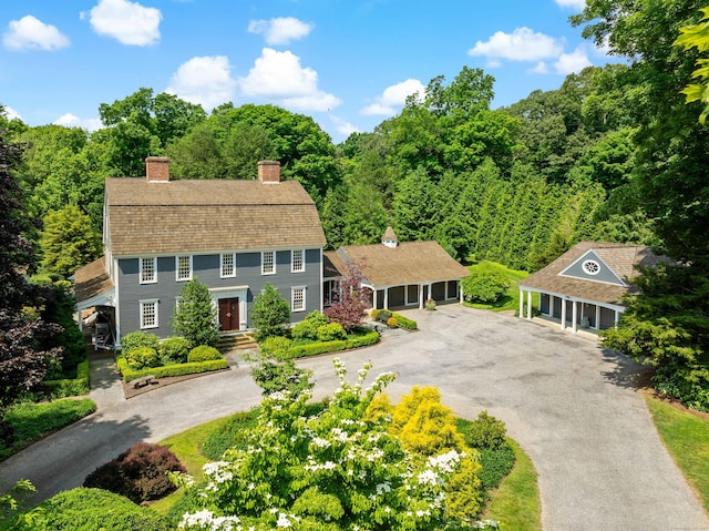 173 Highwoods Dr, Guilford, CT 06437 - view of front of property featuring a chimney, a view of trees, and asphalt driveway