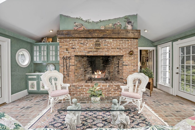 173 Highwoods Dr, Guilford, CT 06437 - living area featuring brick floors, lofted ceiling, and a brick fireplace