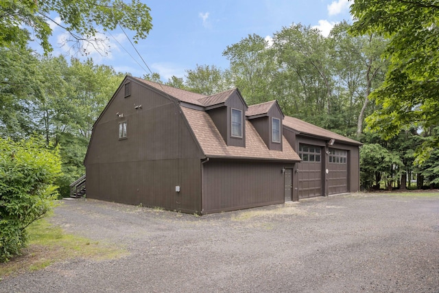173 Highwoods Dr, Guilford, CT 06437 - view of property exterior with a shingled roof, a garage, and view of scattered trees