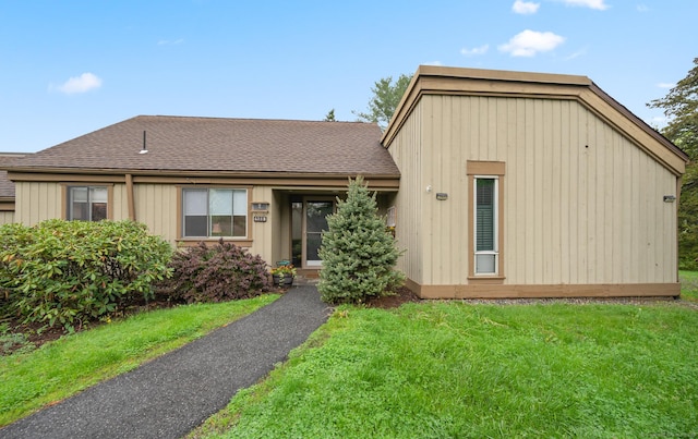 view of front of house with a front yard and roof with shingles