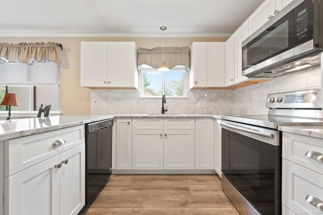 kitchen with appliances with stainless steel finishes, a sink, white cabinets, and light wood-style floors