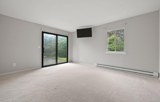 carpeted spare room featuring baseboard heating and baseboards