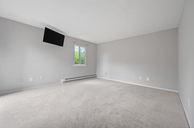 unfurnished room with baseboard heating, carpet flooring, and baseboards