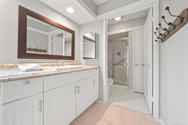bathroom featuring a shower stall, vanity, toilet, tile patterned floors, and baseboards