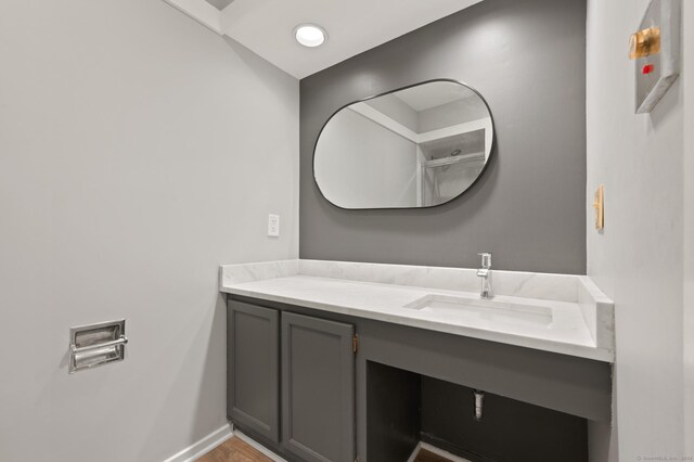 bathroom with vanity, baseboards, and wood finished floors