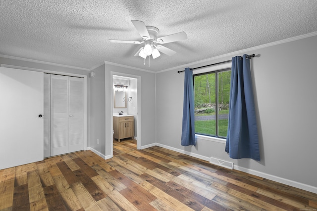 27 Honey Hill Rd, East Haddam, CT 06423 - unfurnished bedroom featuring a textured ceiling, wood-type flooring, crown molding, a sink, and a closet
