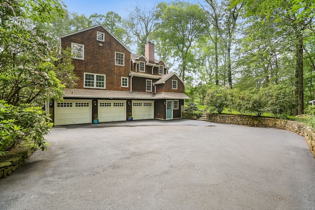 41 Little Brook Rd, Wilton, CT 06897 - view of front facade with asphalt driveway, a garage, and a chimney