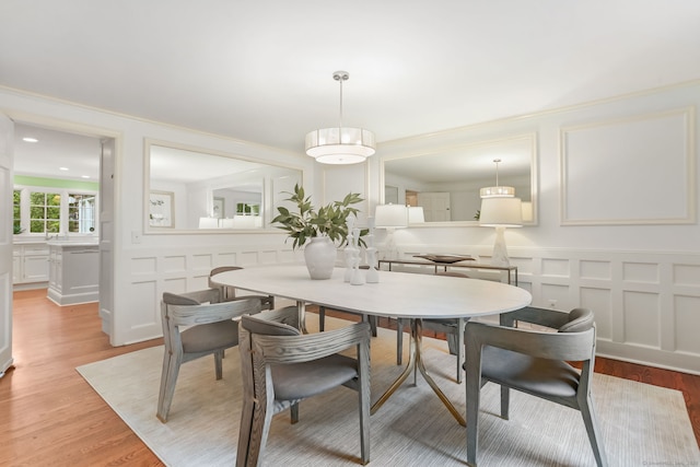 41 Little Brook Rd, Wilton, CT 06897 - dining area with a decorative wall, light wood-style floors, ornamental molding, and wainscoting