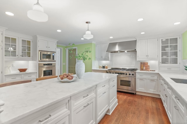 41 Little Brook Rd, Wilton, CT 06897 - kitchen with stainless steel appliances, wall chimney exhaust hood, recessed lighting, hanging light fixtures, and white cabinets