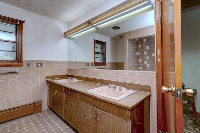23 Pinesbridge Rd, Oxford, CT 06478 - bathroom with tile walls, baseboard heating, double vanity, a wainscoted wall, and plenty of natural light