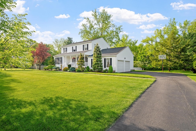 view of front of house with a porch, a garage, a front lawn, and asphalt driveway
