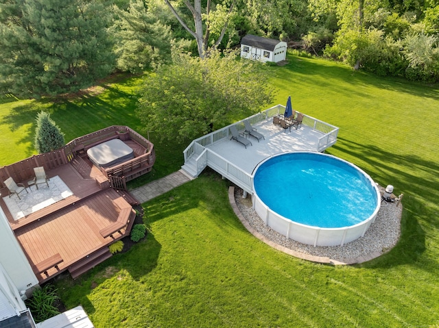 swimming pool with a deck, a storage unit, an outdoor structure, a yard, and outdoor dining space