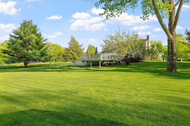 view of grassy yard featuring a deck