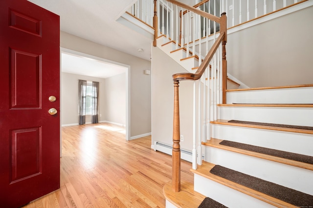 foyer entrance with wood finished floors, stairs, and baseboards