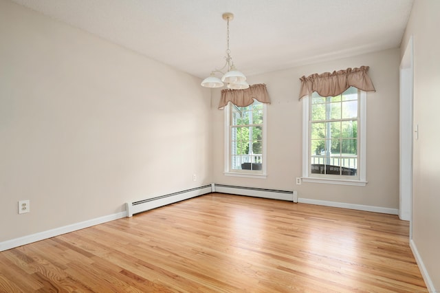 unfurnished room with light wood-style floors, baseboards, a chandelier, and a baseboard radiator