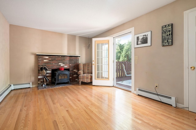 unfurnished living room featuring baseboard heating, a wood stove, and wood finished floors