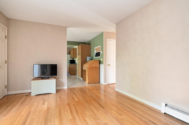 unfurnished living room featuring a baseboard heating unit, light wood finished floors, and baseboards