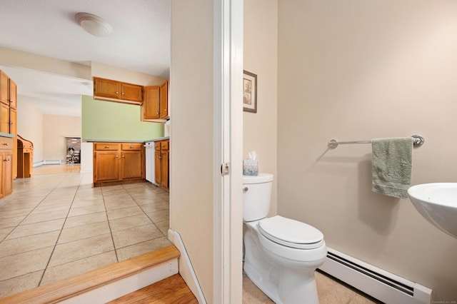 bathroom with a baseboard heating unit, toilet, and tile patterned floors
