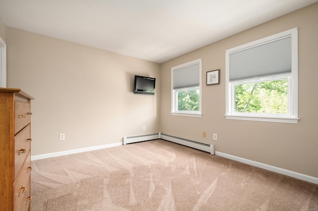 carpeted spare room featuring baseboards and a baseboard heating unit