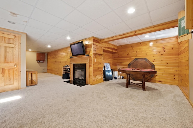 playroom with carpet floors, wood walls, a fireplace with flush hearth, recessed lighting, and a drop ceiling