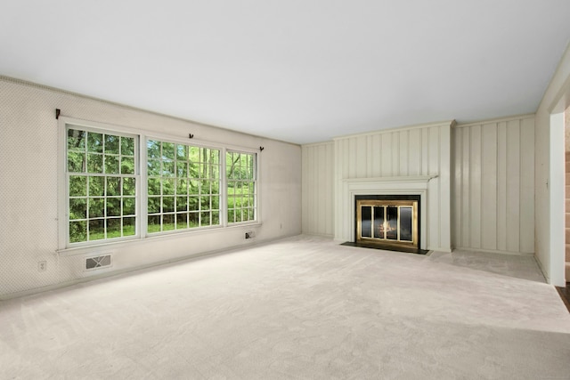 unfurnished living room with a fireplace with flush hearth and carpet flooring