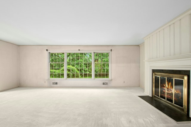 unfurnished living room with a fireplace with flush hearth and carpet floors