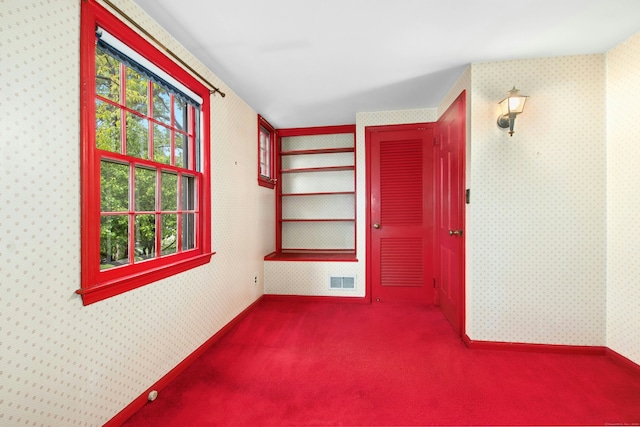 spare room featuring carpet and wallpapered walls