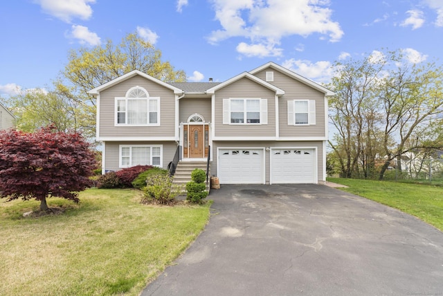 bi-level home with driveway, a garage, and a front yard