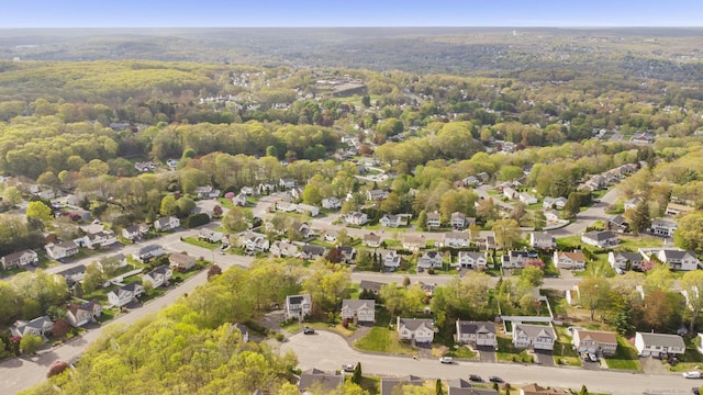 aerial overview of property's location featuring a forest and nearby suburban area