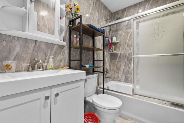 full bathroom with toilet, vanity, tasteful backsplash, and bath / shower combo with glass door