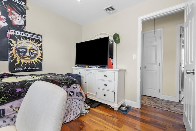 bedroom with dark wood-type flooring and baseboards