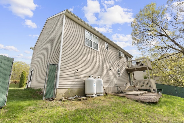 rear view of property featuring a yard and a deck