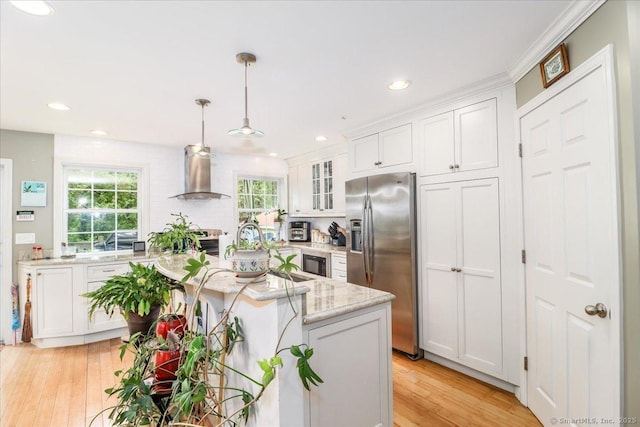 37A/K/A27 Oregon Ave, East Haven, CT 06512 - kitchen with appliances with stainless steel finishes, wall chimney exhaust hood, white cabinets, light wood-style floors, and pendant lighting