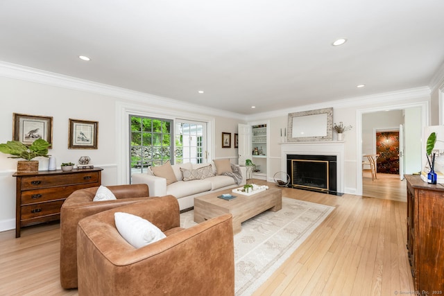 living room with crown molding, light wood-style flooring, a fireplace with flush hearth, and recessed lighting