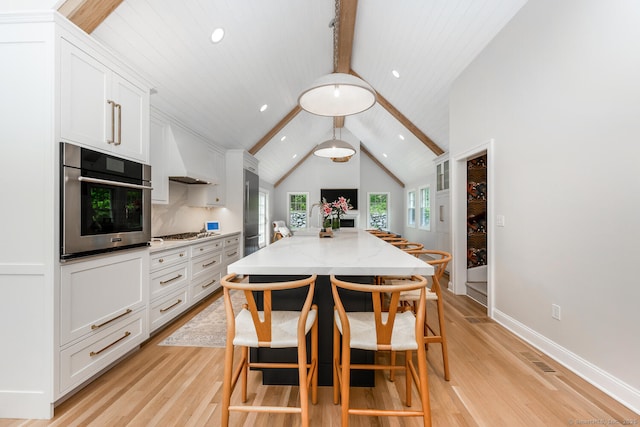 kitchen featuring appliances with stainless steel finishes, light wood finished floors, white cabinetry, recessed lighting, and light stone counters