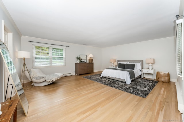 bedroom with wood finished floors, baseboards, and ornamental molding