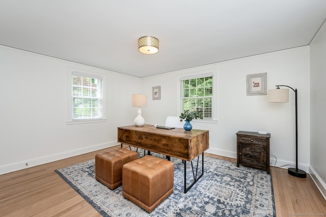 home office featuring light wood-type flooring, baseboards, and healthy amount of natural light