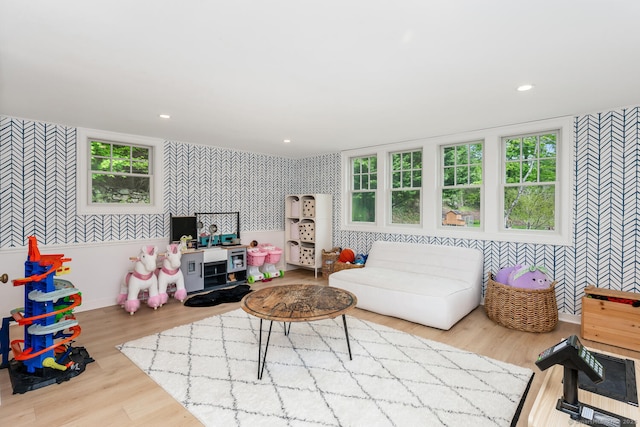 living room featuring wallpapered walls, an accent wall, wood finished floors, plenty of natural light, and recessed lighting