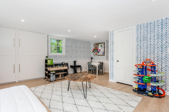 bedroom with wallpapered walls, wood finished floors, and recessed lighting