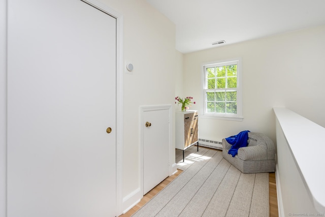 interior space featuring a baseboard heating unit and light wood-style floors