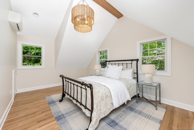 bedroom featuring an AC wall unit, wood finished floors, and multiple windows