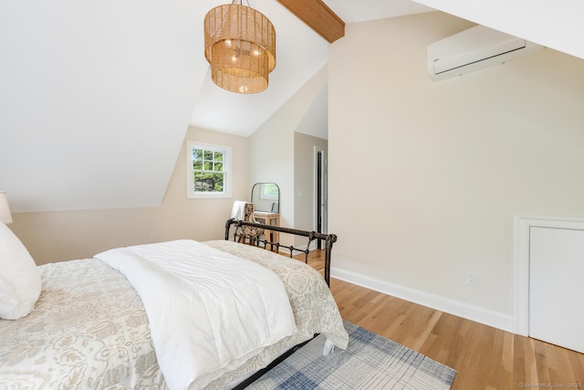 bedroom with an AC wall unit, wood finished floors, and baseboards