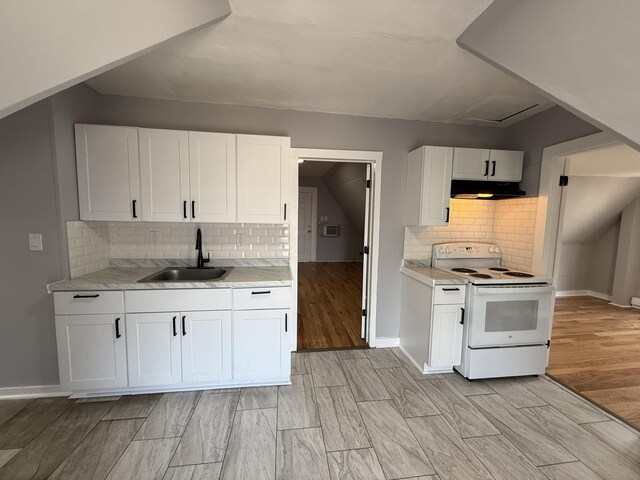 kitchen with white electric stove, a sink, light countertops, backsplash, and white cabinetry