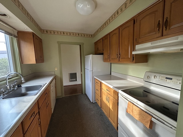 kitchen with under cabinet range hood, brown cabinetry, white appliances, a sink, and light countertops