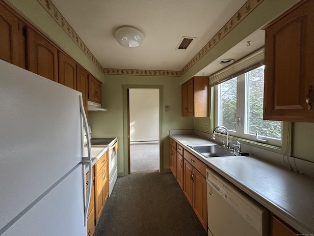 kitchen with a sink, white appliances, visible vents, light countertops, and dark carpet