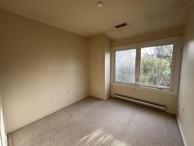 carpeted empty room with baseboards, a wealth of natural light, baseboard heating, and visible vents