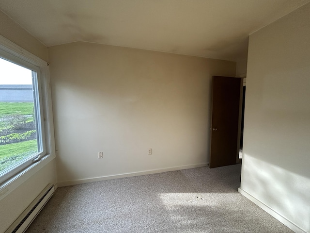 carpeted empty room with vaulted ceiling, baseboards, a baseboard radiator, and a healthy amount of sunlight