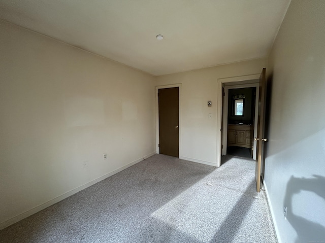 unfurnished bedroom featuring baseboards and light colored carpet