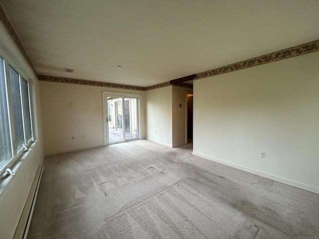 spare room featuring light colored carpet, baseboards, baseboard heating, and visible vents