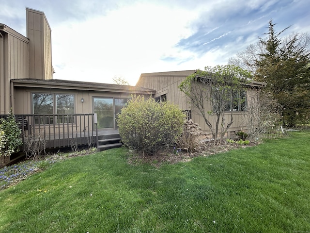 view of property exterior featuring a lawn and a wooden deck